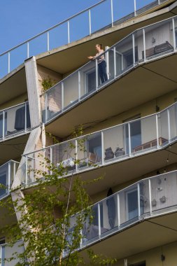 Stockholm, İsveç A, Norra Curgardstaden 'de Bjork ve Plaza adında bir modern binanın balkonunda duruyor..