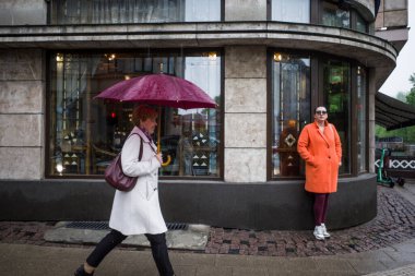 Riga, Letonya, iki kadın eski şehrin bir köşesinde yağmurda.