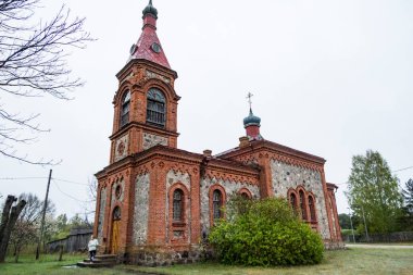 Cape Kolka, Letonya, Yerel ve kapalı bir kilisenin merdivenlerinde bir kişi.