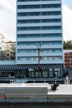 Stockholm, İsveç Liljeholmskajen bölgesinde bir yüzme platformunda oturan insanlar suyu temizler..