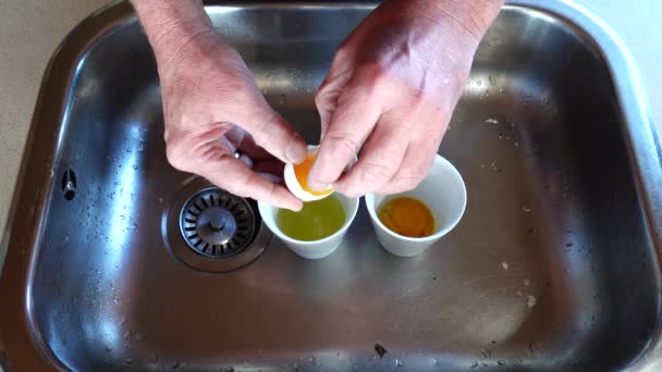一个人在水槽里劈开一个鸡蛋 把蛋清和蛋黄分开 — 图库视频影像