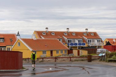 Skagen, Danimarka Geleneksel evlerin yakınında bir adam yürüyor.