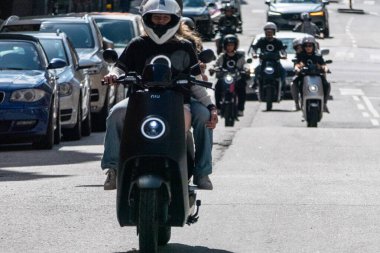 Stockholm, İsveç. Bir grup insan Niu elektrikli scooterlara biniyor..