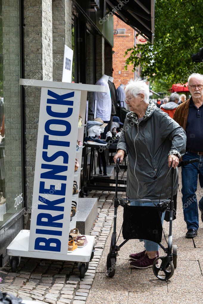 Hjorring, Denmark A senior woman with a walker looks at a Birkenstock display at a shoe store.