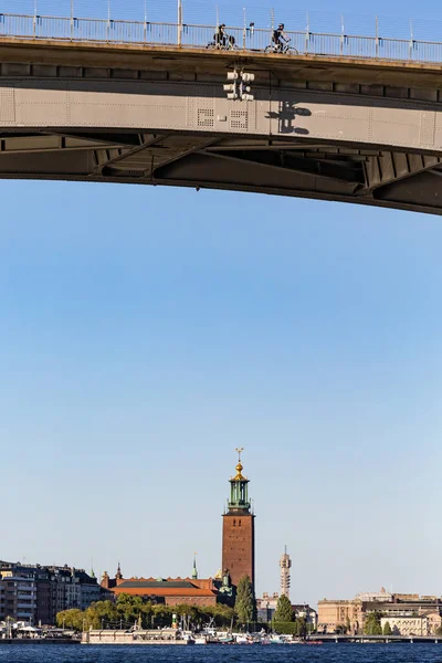 Estocolmo Suecia Los Ciclistas Cruzan Puente Occidental Con Ayuntamiento Fondo — Foto de Stock