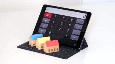 Bir tablet hesap makinesi ve küçük evler. 