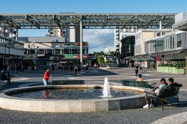 Stockholm, İsveç Vallingby banliyösündeki çeşmenin etrafında oturan insanlar.