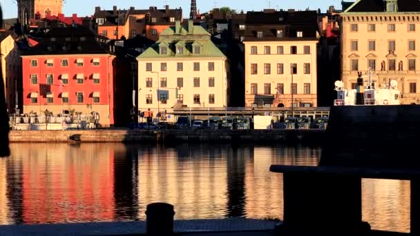 瑞典斯德哥尔摩一位男子坐在骷髅人的长椅上 俯瞰着水和古城 — 图库视频影像