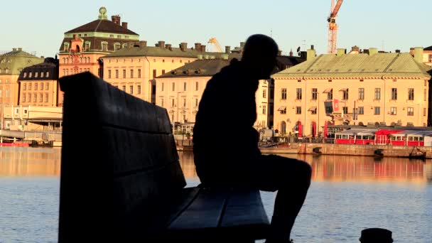 Sztokholm Szwecja Człowiek Siedzi Ławce Skeppsholmen Widokiem Wodę Gamla Stan — Wideo stockowe