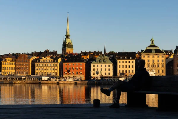 Sztokholm Szwecja Człowiek Siedzi Ławce Skeppsholmen Widokiem Wodę Gamla Stan — Zdjęcie stockowe