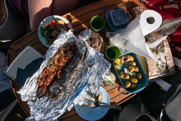 在船上享用野餐晚餐 船上有蔬菜 香肠和新鲜土豆 — 图库照片