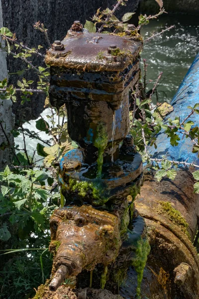 Ksamil, Albania, A water pipe and pump along an irrigation canal.