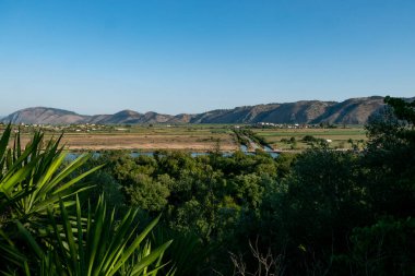 Arnavutluk 'un Ksamil kenti ve Butrint Gölü' nü çevreleyen tarım sahalarının manzarası.