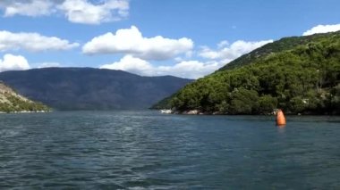 Arnavutluk 'un Ksamil kentinde küçük bir midye balıkçı teknesi midye toplamak için Butrint Gölü' ndeki midye yataklarına gidiyor. 