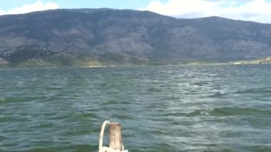 Arnavutluk 'un Ksamil kentinde küçük bir midye balıkçı teknesi midye toplamak için Butrint Gölü' ndeki midye yataklarına gidiyor. 