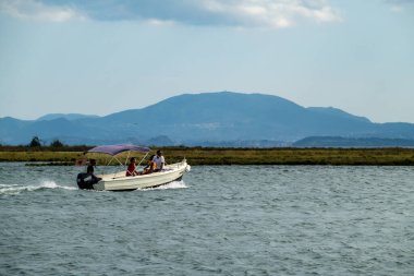 Arnavutluk 'un Ksamil kenti ve küçük bir motorlu tekne turistleri Adriyatik' teki Ali Paşa Kalesi 'ne götürüyor.