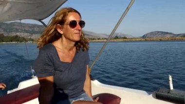 Arnavutluk 'un Ksamil kentinde Butrint Gölü' nde gün batımında küçük bir tekneye binen bir kadın turist görülüyor.. 