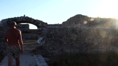 Ksamil, Albania A male tourist walks in shorts on the Ali Pasha Castle island.  