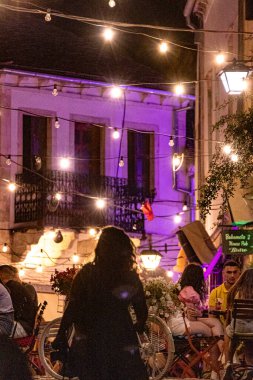Cirokaster, Arnavutluk Geceleri taşlı bir sokakta yürüyen insanlar ve bir restoran.