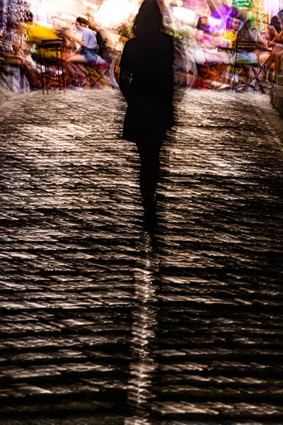 Gjirokaster, Albania A person walks at night on a cobblestoned street.