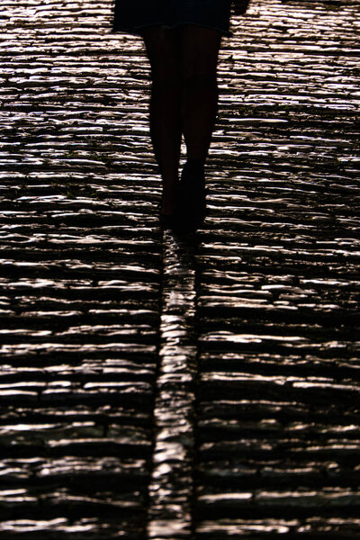 Gjirokaster, Albania A person walks at night on a cobblestoned street.