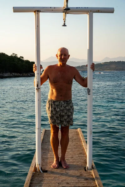 Ksamil, Albania A fit middle-aged man poses on the dock