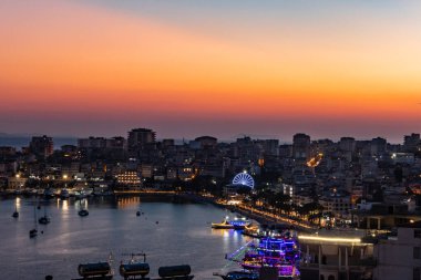 Arnavutluk 'un Saranda kenti ve kıyı şeridi gece ve günbatımından hemen sonra.