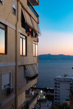 Arnavutluk 'un Saranda kenti ve kıyı şeridi gece ve günbatımından hemen sonra.