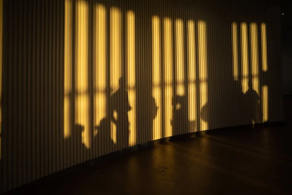 Corfu, Greece, People in-line and in shadow at the airport gate at  sunset.