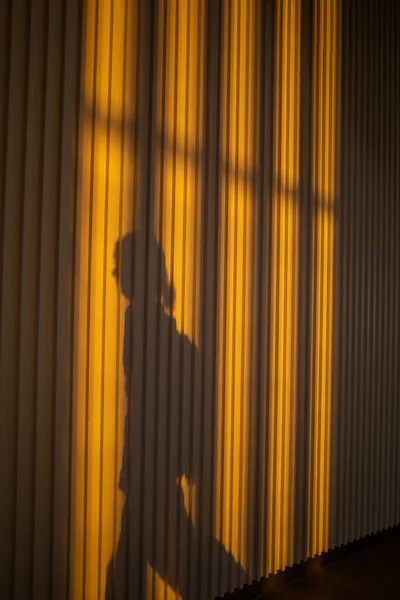 Corfu, Greece, People in-line and in shadow at the airport gate at  sunset.