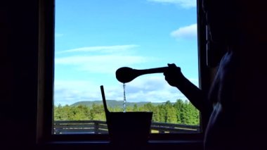 Sorsele, Sweden A man pours water in a sauna with a view over the Lappland countryside