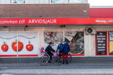 Arvidsjaur, Sweden Men chatting in front of the local ICA supermarket.