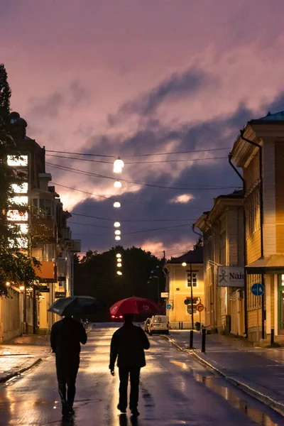 Skelleftea Sweden Two Men Umbrellas Walking Rainy Street Night — Fotografia de Stock