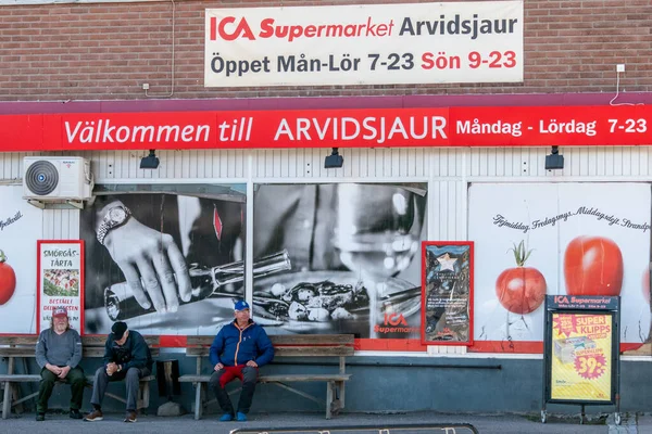 Arvidsjaur, Sweden Men chatting in front of the local ICA supermarket.