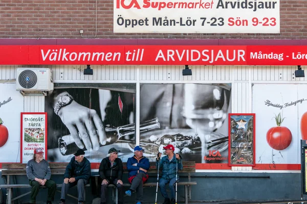 Arvidsjaur, Sweden Men chatting in front of the local ICA supermarket.