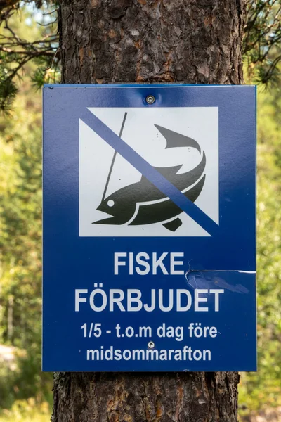 Umea, Sweden A sign posted on a tree says No Fishing in Swedish between Jan and June.