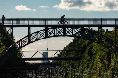 Copenhagen, Denmark A man cycles over a pedestrian and cycle bridge over the railroad track in the Carlsberg Station district.