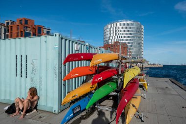 Copenhagen, Denmark A man suns next to kayaks in the Nordhavnen, or North Harbor, district.