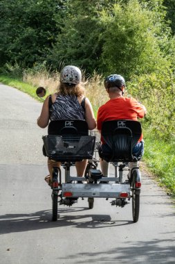 Copenhagen, Denmark,A man with Down's Syndrome rides a. tandem bike with a caregiver.