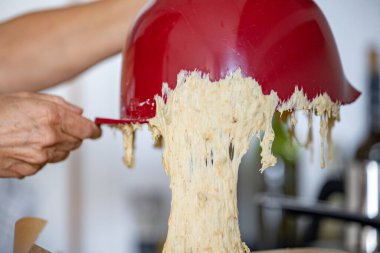 Ekmek hamuru bir mutfak kasesinde mayalanır ve kabın üzerine dökülür..