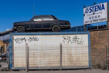 Kopenhag, Danimarka Paslı ve eski bir Mercedes arabası şehrin kenar mahallelerinde geri dönüşüm için hurdalıkta duruyor.