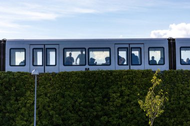 Kopenhag, Danimarka Orestad 'daki yüksek metro yeşil çalıların üzerinden geçiyor..