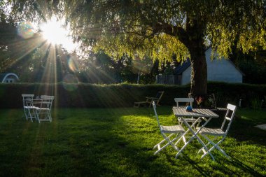 Moen, Danimarka, arka bahçe ve batan güneşin altında bir masa..