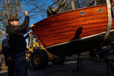 Stockholm, İsveç Tekne Kulübü Üyeleri, karada kış depolama için birbirlerinin teknelerini çekmeye yardım ediyorlar..
