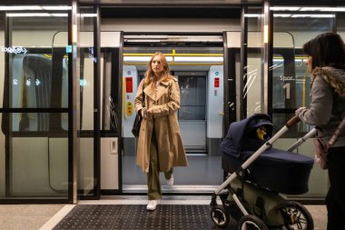 Kopenhag, Danimarka. Genç bir kadın Kopenhag metrosunda trenden iniyor..