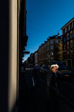 Kopenhag, Danimarka, Frederiksberg bölgesindeki güneşli Gammel Kongevej caddesinde bir kişi yürüyor.