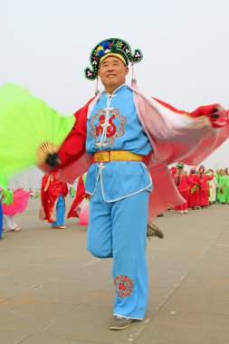 İnsanlar renkli kıyafetler giyer, Yanko dans gösterileri yapar.