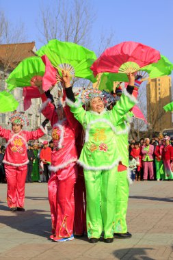 İnsanlar renkli kıyafetler giyer, Yanko dans gösterileri yapar.