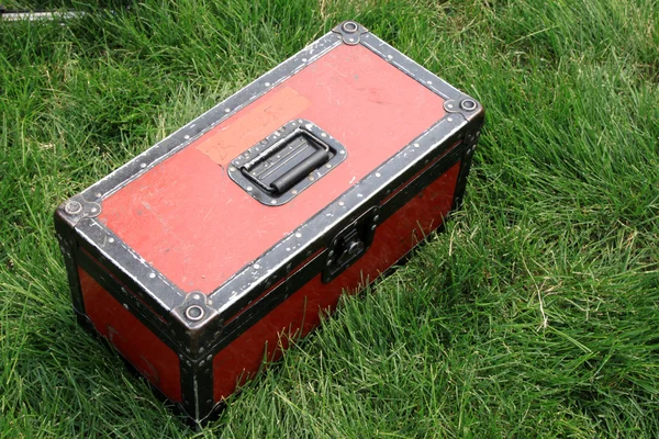 Red tin box on a green lawn — Stock Photo, Image