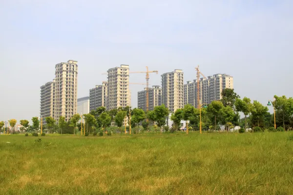 Immeubles de grande hauteur et plantes vertes dans un parc — Photo